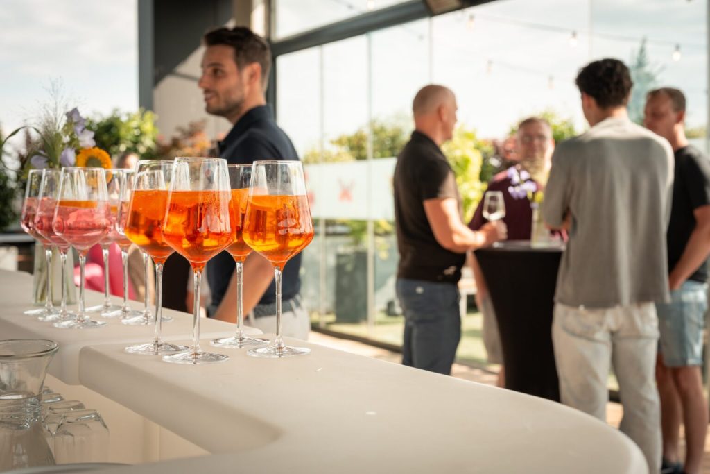 Menschen genießen Cocktails bei einer Afterwork-Veranstaltung auf der Terrasse des Technopark Raaba.
