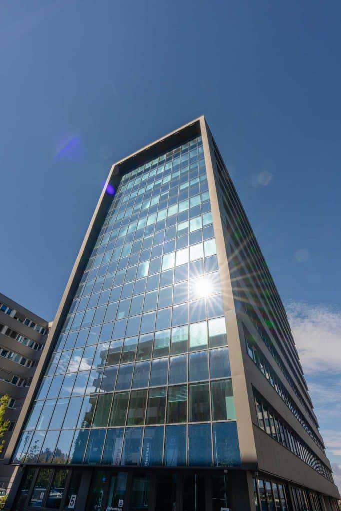 Modernes Bürogebäude mit Glasfassade im Sonnenlicht, Technopark Raaba.