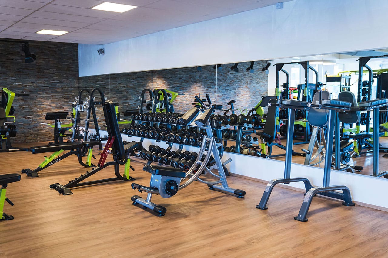 Fitnessstudio im Technopark Raaba mit modernen Geräten und Spiegelwand.