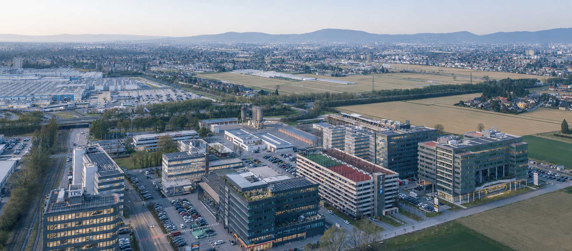 Panoramablick auf den Technopark Raaba mit modernen Bürogebäuden und umgebender Landschaft.